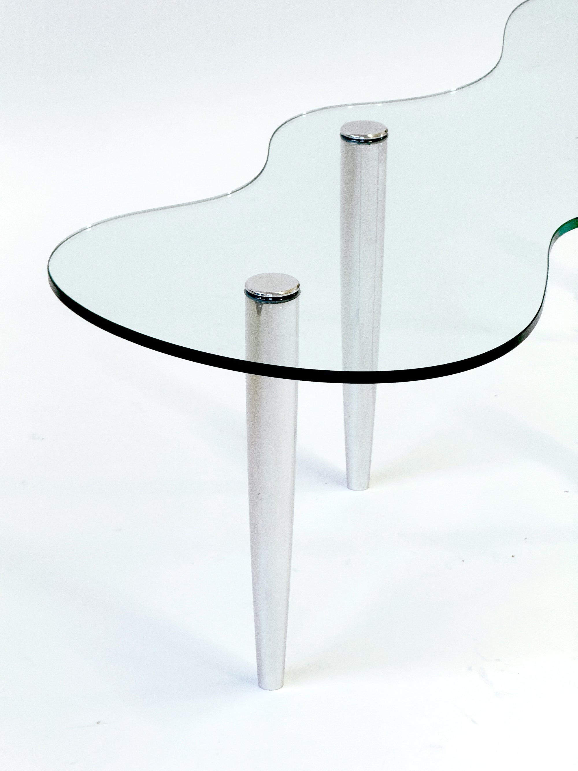 Glass table with chrome legs on a white background