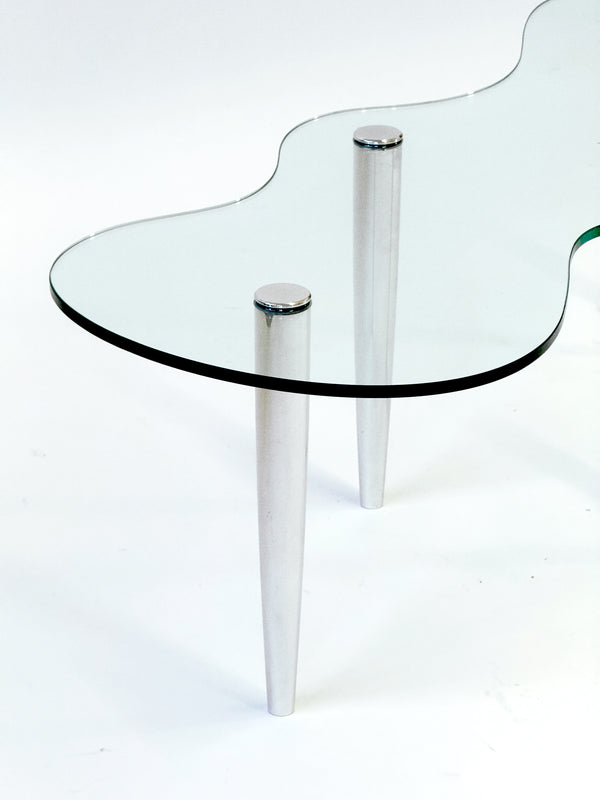 Glass table with chrome legs on a white background
